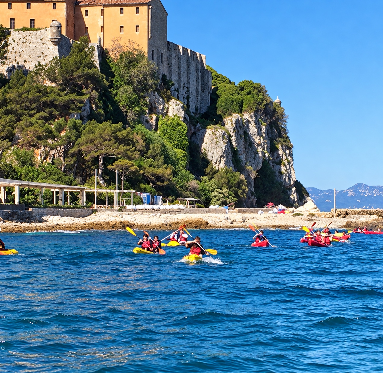 A group kayaking beside the island coastline