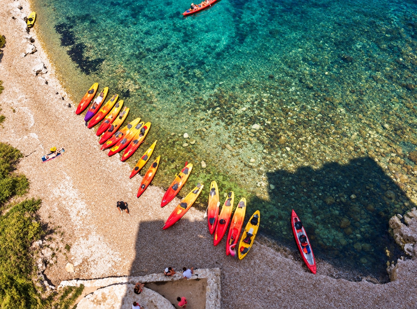 Des kayaks rassemblés sur une plage, vus du ciel.