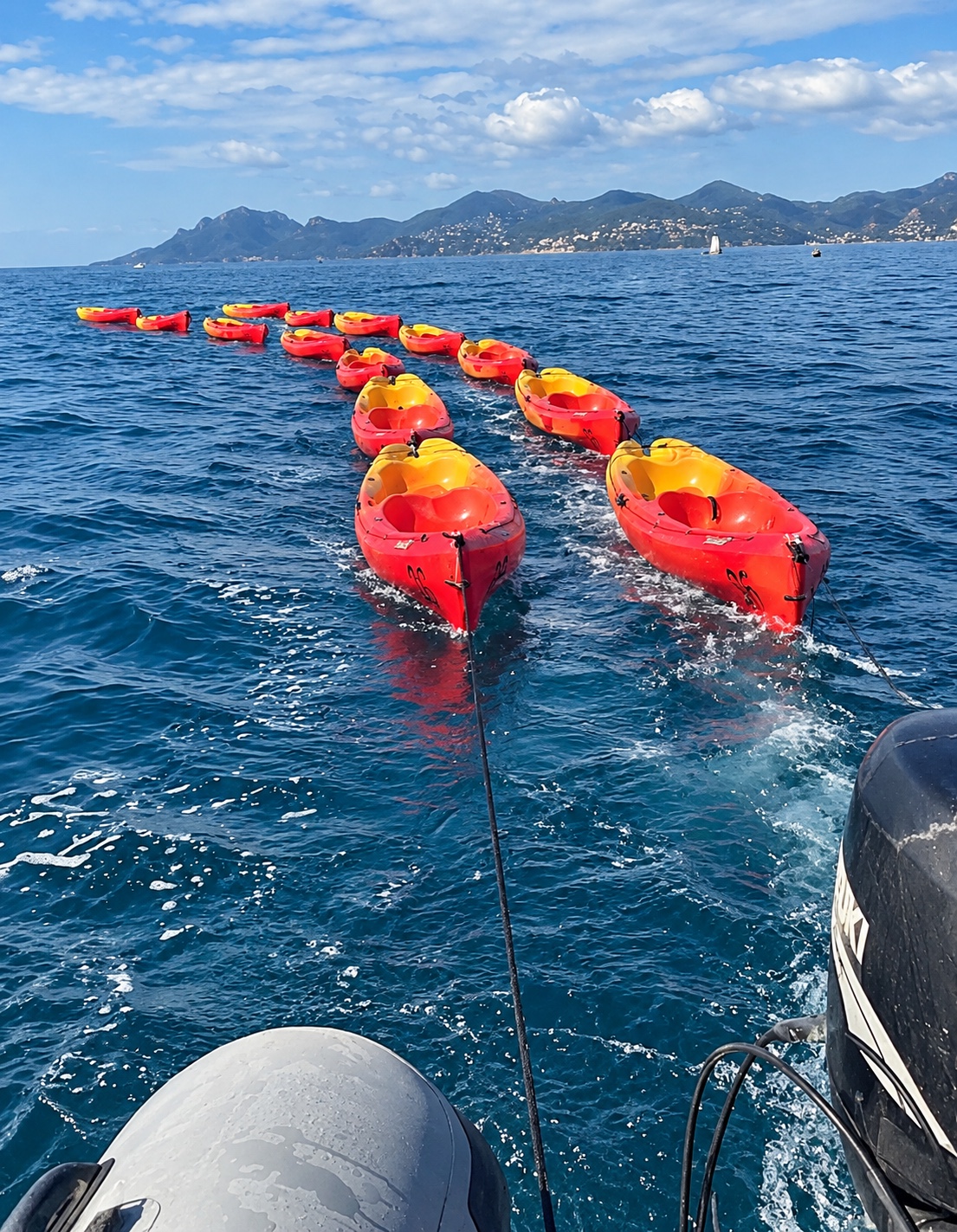 Kayaks being towed by a Zodiac during an equipment transfer